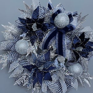 Flocked Christmas wreath with navy poinsettias and silver glitter ornaments