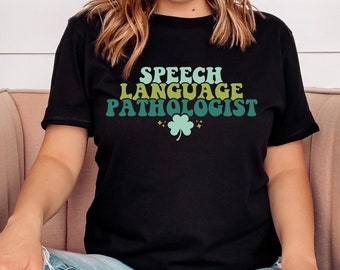 May include: A black t-shirt with the text "SPEECH LANGUAGE PATHOLOGIST" in a retro font with a green shamrock.