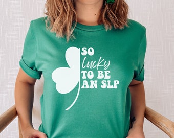 May include: A green t-shirt with a white shamrock and the text "SO lucky TO BE AN SLP".