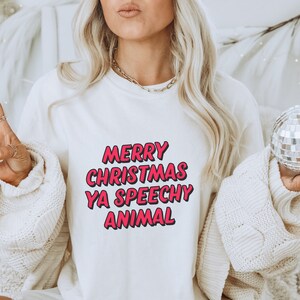 May include: White sweatshirt with a pink graphic that says "Merry Christmas Ya Speechy Animal".