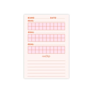 May include: A rectangular, light pink goal tracker notepad with peach-colored text and grid boxes. The notepad includes sections for name, date, and three goals, each with a 10-box grid. The word "notes" is at the bottom, with lined space below.