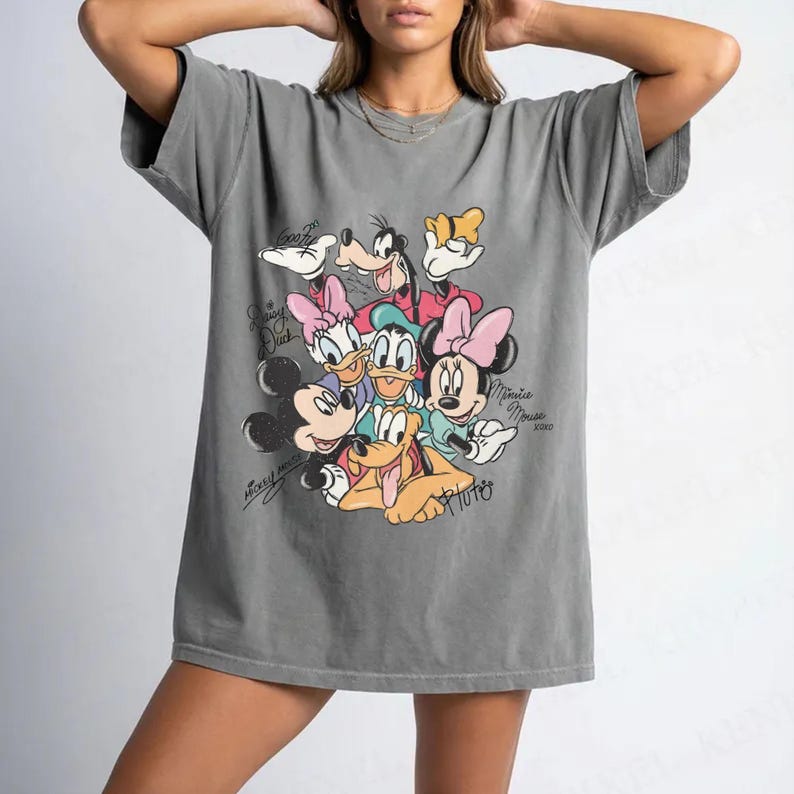 May include: Gray t-shirt featuring a graphic of Disney characters including Mickey Mouse, Minnie Mouse, Donald Duck, Daisy Duck, Goofy, and Pluto. The graphic has a vintage style with the characters' names in cursive.