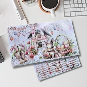 Könnte beinhalten: Ein druckbares Oster-Spielbrett mit einer niedlichen Hasenillustration, einem Haus mit dem Wort "Ostereier" darauf und einem Korb mit bunten Eiern. Das Spielbrett hat ein Gitter aus nummerierten Feldern und einen Bereich, in dem die Spieler ihren Fortschritt markieren können.