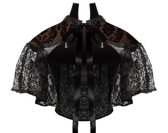 May include: Black lace bolero with a brown velvet collar and a black satin ribbon tie. The bolero has a scalloped edge and a delicate floral pattern.