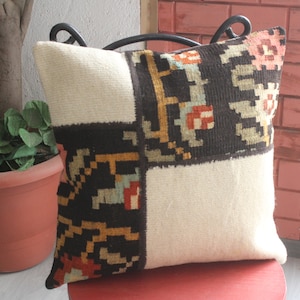 May include: A white and brown patterned pillow with a geometric design. The pillow is made of woven fabric and has a soft, plush texture.