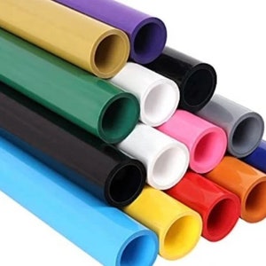 Op de afbeelding: Een set van 12 kleurrijke vinylrollen, elk met een andere kleur, waaronder blauw, groen, geel, oranje, rood, roze, wit, grijs, zwart en paars. De rollen zijn in een driehoekige vorm gerangschikt, met de uiteinden van de rollen zichtbaar.