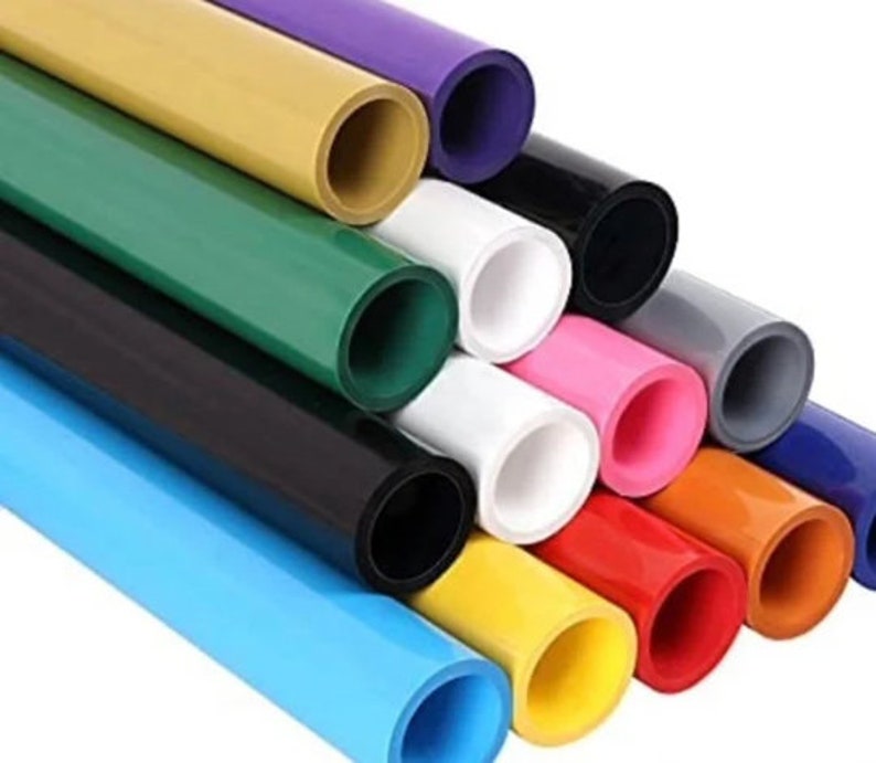 Op de afbeelding: Een set van 12 kleurrijke vinylrollen, elk met een andere kleur, waaronder blauw, groen, geel, oranje, rood, roze, wit, grijs, zwart en paars. De rollen zijn in een driehoekige vorm gerangschikt, met de uiteinden van de rollen zichtbaar.