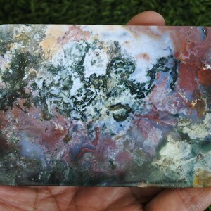 May include: A rectangular slab of polished moss agate featuring a complex, organic pattern of deep forest green, earthy terracotta red, creamy white, and translucent grey inclusions throughout the smooth, flat stone surface.