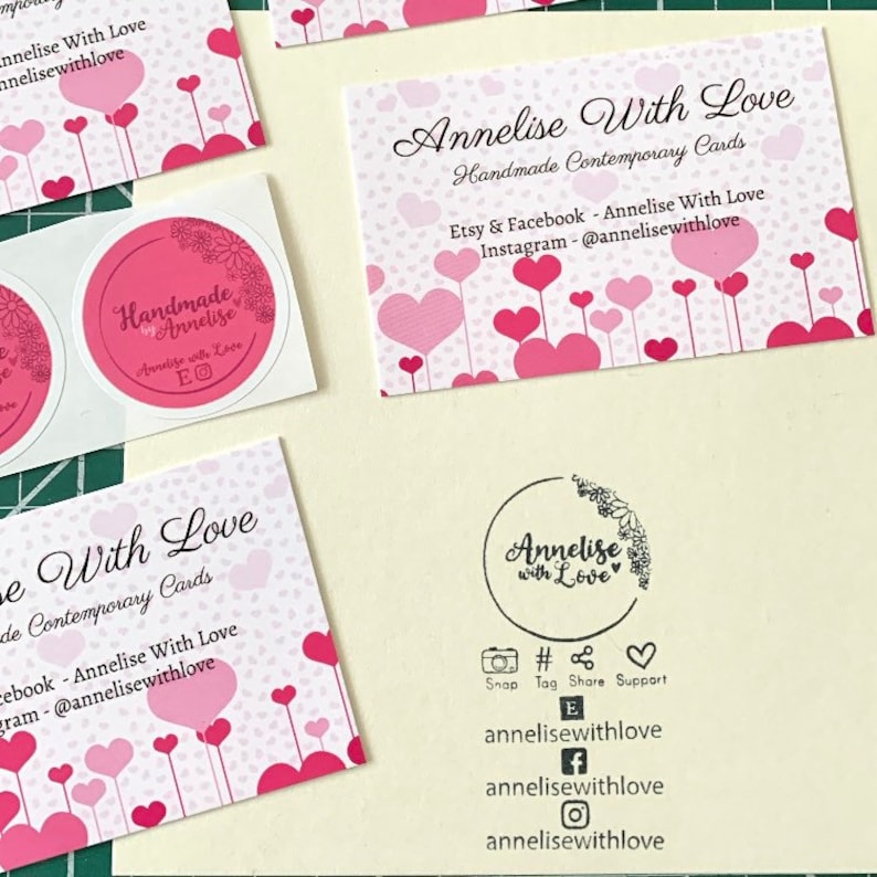 May include: A pink and white business card with a heart pattern and the text "Annelise With Love Handmade Contemporary Cards" and "Etsy & Facebook - Annelise With Love Instagram - @annelisewithlove".