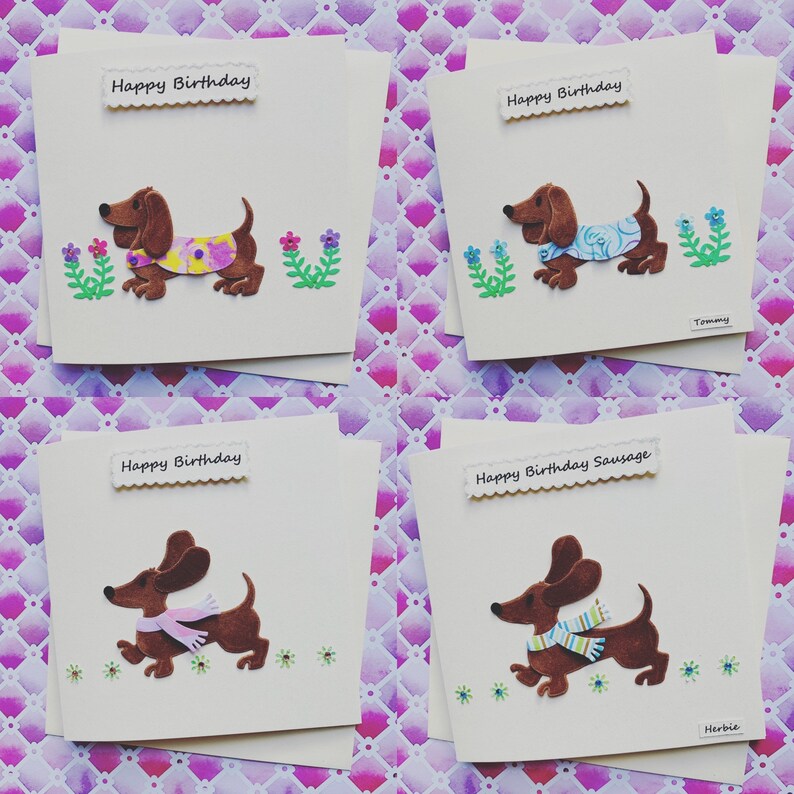 May include: Four handmade greeting cards featuring a brown dachshund dog with different coloured scarves and flowers. The cards say "Happy Birthday" and "Happy Birthday Sausage".
