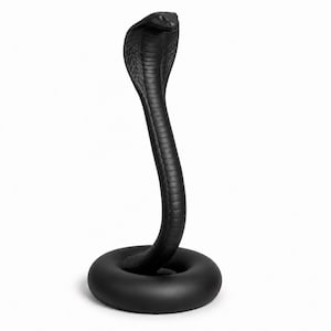 Könnte beinhalten: Eine mattschwarze Kobra-Figur, die aufrecht auf einem runden Sockel steht. Die Schlange hat eine gespreizte Haube mit detaillierten Schuppenstrukturen entlang des Halses und Körpers und erhebt sich aus einem glatten, ringförmigen Fundament.