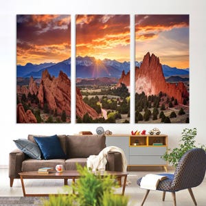 May include: A three-panel canvas print featuring a scenic landscape of red rock formations at sunset. The sun is setting behind a mountain range, casting a warm glow over the scene. The print is perfect for adding a touch of nature to any room.