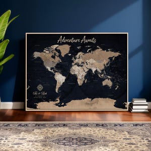 May include: A framed world map with a dark blue background and tan continents. The words "Adventure Awaits" are written in cursive at the top. The map includes the names "Tim & Beth" at the bottom.