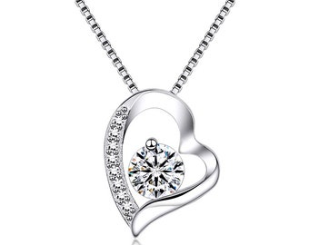 May include: A silver necklace with a heart-shaped pendant featuring a sparkling round stone surrounded by smaller stones. The heart pendant has a delicate open design.
