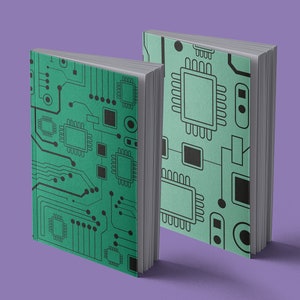 May include: Two green notebooks with a circuit board design. The notebooks are closed and standing upright on a purple surface.
