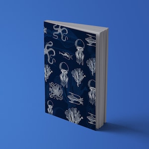 K&ouml;nnte beinhalten: Ein Hardcover-Buch mit marineblauem Einband, verziert mit wei&szlig;en Illustrationen von Meereslebewesen wie Quallen und Tintenfischen. Das Buch steht vor einem einfarbigen blauen Hintergrund.