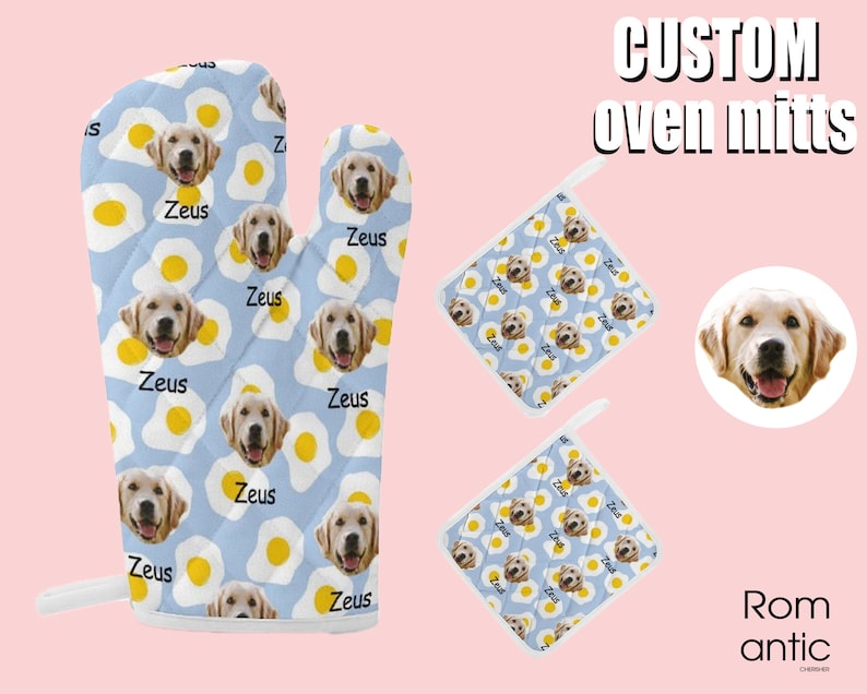 May include: Custom oven mitts and pot holders featuring a light blue background with a pattern of fried eggs and a golden retriever's face. The name "Zeus" is printed on the mitts. The set includes an oven mitt and two pot holders.