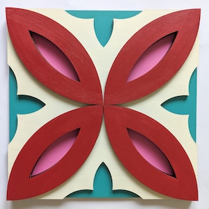 May include: A square wall art piece with a geometric design. The design features four red leaf shapes with pink cutouts, set against a white background with teal accents.