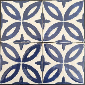 May include: Four square ceramic tiles with a white background and a blue geometric pattern. The pattern is made up of overlapping ovals and a four-pointed star in the center of each tile.