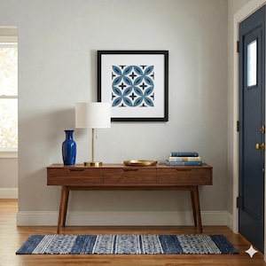 May include: A mid-century modern entryway scene featuring a wooden console table with three drawers, a blue vase, a brass lamp, and a framed geometric art print. A blue and white patterned rug and a navy blue door complete the decor.