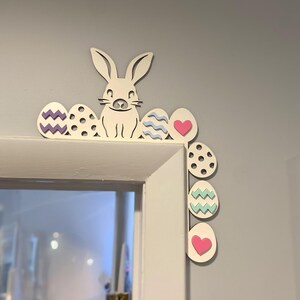 Happy Easter door corner decoration with bunny rabbit and Easter eggs decorated with acrylic designs in pink, purple, blue, and mint green