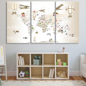 Può includere: Una stampa su tela a tre pannelli di una mappa del mondo con illustrazioni in stile vintage di aeroplani e mongolfiere. La mappa include bandiere nazionali e immagini di vita marina. L'opera d'arte è sopra un mobile contenitore bianco.
