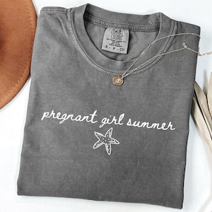 May include: A gray t-shirt with the text "pregnant girl summer" and a white starfish graphic.