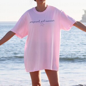 May include: A pink t-shirt with the text "pregnant girl summer" and a small starfish graphic.