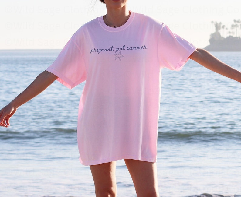 May include: A pink t-shirt with the text "pregnant girl summer" and a small starfish graphic.