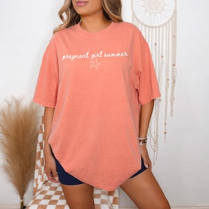 May include: A coral colored oversized t-shirt with the text "pregnant girl summer" and a white starfish graphic.