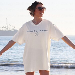 May include: A white t-shirt with the text "pregnant girl summer" and a blue starfish graphic.