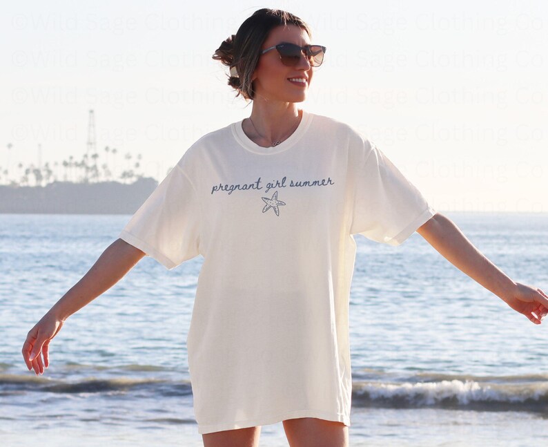 May include: A white t-shirt with the text "pregnant girl summer" and a blue starfish graphic.