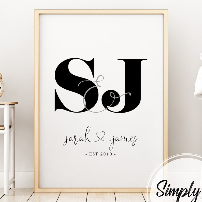 May include: Black and white print with the initials "SJ" in a stylized font, with a heart and ampersand between the letters. The text "sarah & james - EST 2010 -" is below the initials.