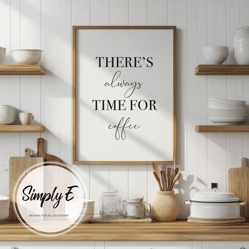 Puede incluir: Una impresi&oacute;n de arte de pared imprimible en blanco y negro con el texto "There's always time for coffee" en un marco de madera marr&oacute;n. La impresi&oacute;n est&aacute; colgada en una pared blanca en un entorno de cocina.