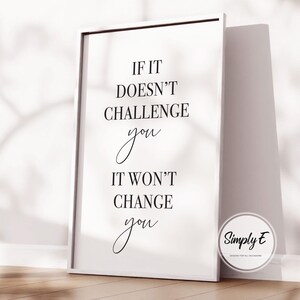 Może przedstawiać: Biała oprawiona grafika z cytatem "If it doesn't challenge you, it won't change you" czcionką w kolorze czarnym. Grafika opiera się o ścianę. Okrągłe logo z napisem "Simply E" znajduje się w prawym dolnym rogu.