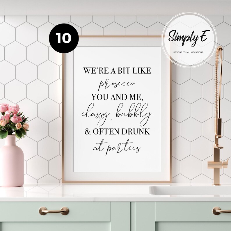 May include: A rectangular wall art print in a thin copper frame featuring black text on a white background that reads: WE'RE A BIT LIKE prosecco YOU AND ME, classy, bubbly & OFTEN DRUNK at parties. The print is displayed in a kitchen setting.