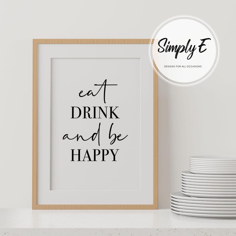 Peut inclure: Une impression encadr&eacute;e avec le texte "eat DRINK and be HAPPY" en &eacute;criture cursive noire sur fond blanc. Le cadre est en bois brun clair.