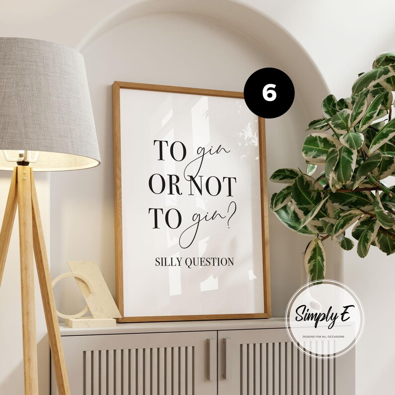 May include: A rectangular framed wall art print with a white background and black text that reads TO gin OR NOT TO gin? SILLY QUESTION. The frame is made of light-coloured wood and is positioned vertically on a flat surface.