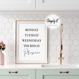 May include: A framed print with the text "Monday, Tuesday, Wednesday, Thursday, Prosecco" in black lettering on a white background.