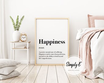 May include: A framed print with a white background and black text that reads "Happiness noun. A positive mental state of wellbeing. Happiness rarely comes from perfection, instead it is the ability to look beyond life's imperfections." The print is framed in a gold frame and has a white mount. The print is hanging on a white wall. The text "Simply E DESIGNS FOR ALL OCCASIONS" is below the print.