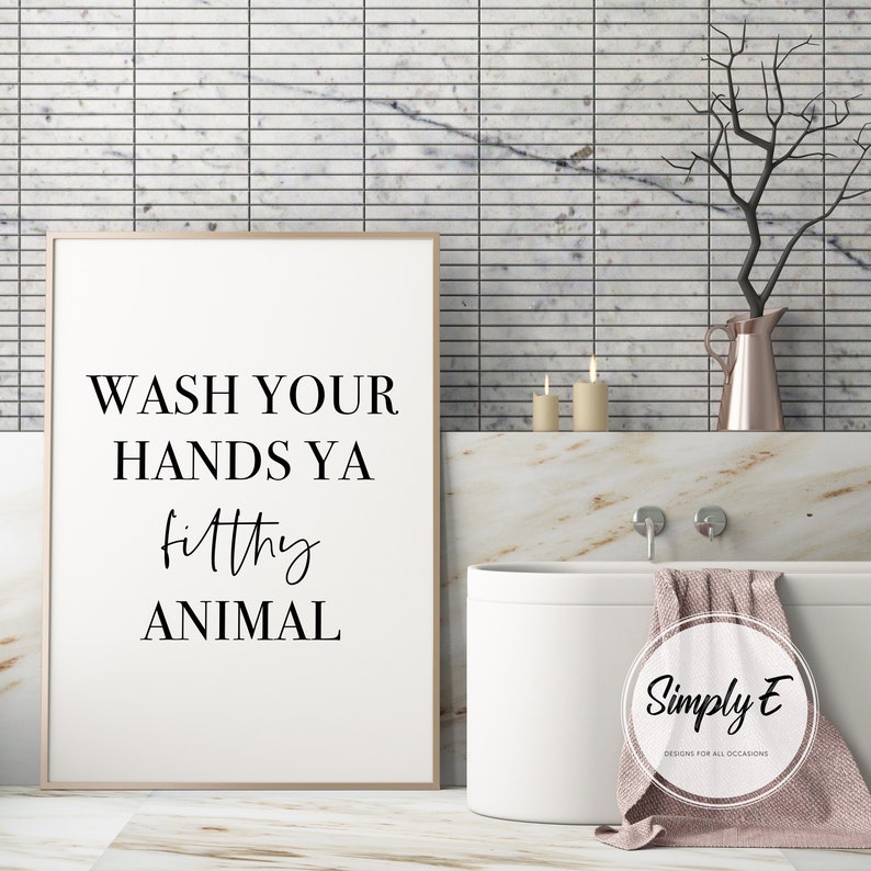 Puede incluir: Impresi&oacute;n enmarcada con el texto "WASH YOUR HANDS YA filthy ANIMAL" en negro. La impresi&oacute;n est&aacute; en un entorno de ba&ntilde;o con una ba&ntilde;era blanca, velas y un jarr&oacute;n decorativo. Decoraci&oacute;n de ba&ntilde;o humor&iacute;stica.