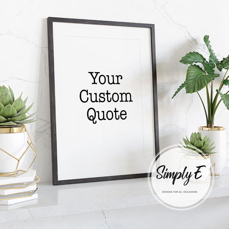 K&ouml;nnte beinhalten: Ein gerahmter Druck mit dem Text "Your Custom Quote" in schwarzer Schrift. Der Rahmen ist dunkel, und der Druck wird auf einer wei&szlig;en Oberfl&auml;che mit Pflanzen in wei&szlig;en und goldenen T&ouml;pfen angezeigt. Das Bild enth&auml;lt das Logo "Simply E".