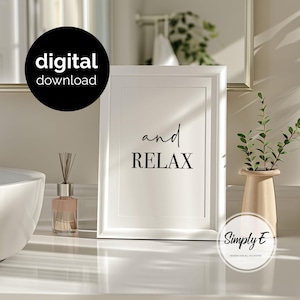 May include: A white rectangular picture frame containing a print with the text "and RELAX" in black lettering. The frame is positioned next to a glass reed diffuser and a light-colored vase with green foliage, featuring a digital download badge.