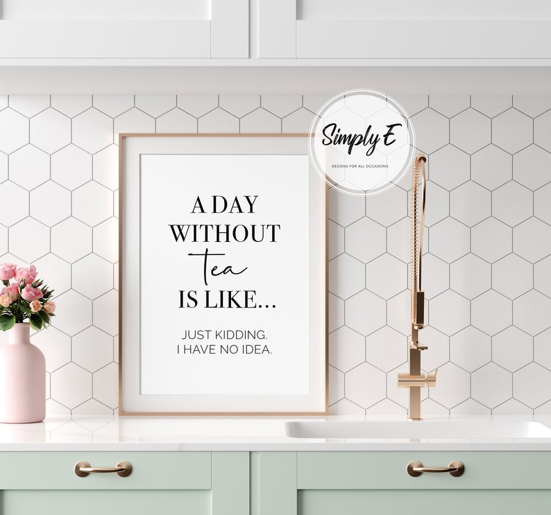 Puede incluir: Una impresi&oacute;n enmarcada con fondo blanco y texto negro que dice "A Day Without Tea Is Like... Just Kidding. I Have No Idea." La impresi&oacute;n est&aacute; colgada en una pared de azulejos blancos sobre un armario verde claro.