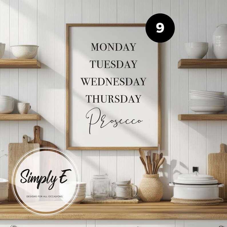 May include: A framed wall art print with a white background and black text that reads MONDAY, TUESDAY, WEDNESDAY, THURSDAY, Prosecco. The print is displayed in a light wood frame, positioned on a kitchen counter with various kitchenware items.