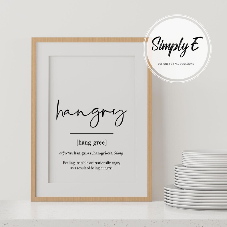 K&ouml;nnte beinhalten: Ein gerahmter Druck mit wei&szlig;em Hintergrund und schwarzem Text, der "hangry" lautet und das Wort als "sich gereizt oder irrational w&uuml;tend f&uuml;hlen, weil man hungrig ist" definiert.