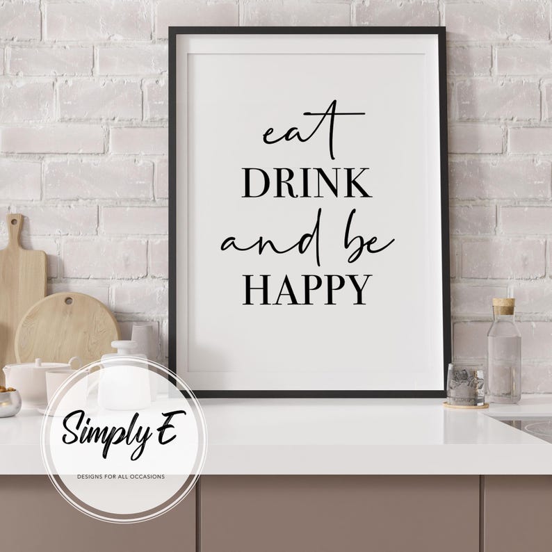 Peut inclure: Impression encadr&eacute;e en noir et blanc avec le texte "eat DRINK and be HAPPY" sur fond blanc. L'impression est accroch&eacute;e &agrave; un mur en briques blanches.