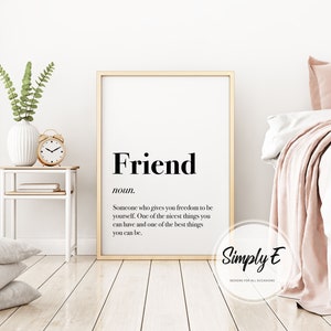 May include: A framed print with the definition of "Friend" in black text on a white background. The definition reads: "Someone who gives you freedom to be yourself. One of the nicest things you can have and one of the best things you can be."