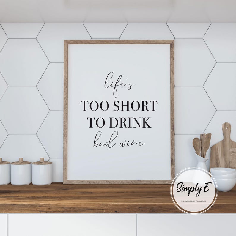 May include: A white ceramic mug with a black handle and the text "But First, Coffee" in a bold, black font. The mug is sitting on a wooden surface. The mug is 4 inches tall.