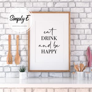 Peut inclure: Une impression encadr&eacute;e avec le texte "eat DRINK and be HAPPY" en lettres noires sur fond blanc. L'impression est accroch&eacute;e &agrave; un mur en briques blanches.